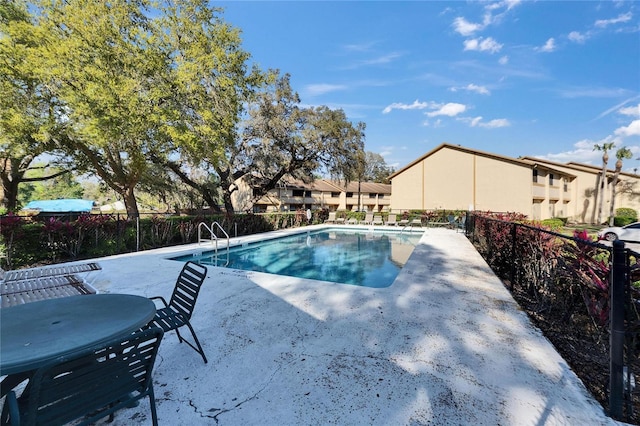 community pool with fence and a patio