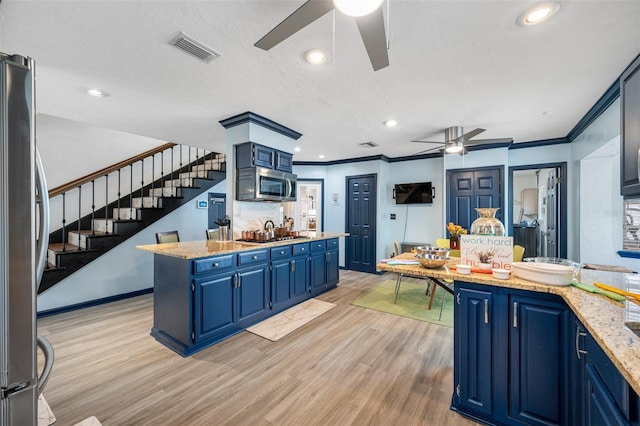 kitchen featuring a center island, stainless steel appliances, light hardwood / wood-style flooring, crown molding, and blue cabinets