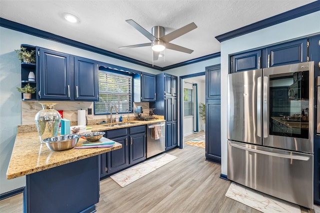 kitchen featuring crown molding, light hardwood / wood-style flooring, sink, blue cabinets, and stainless steel appliances