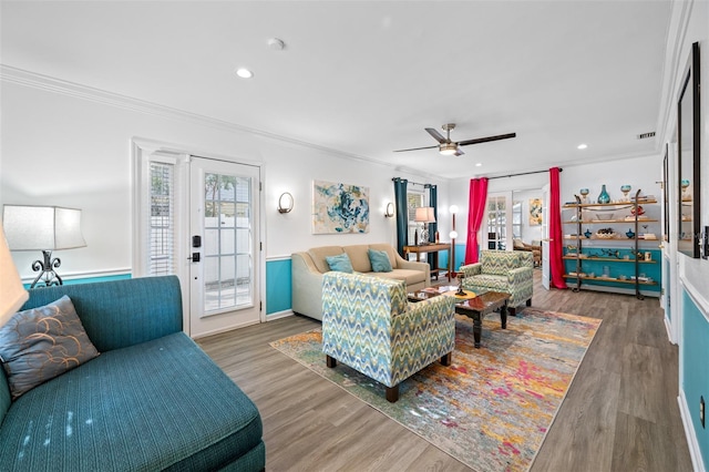 living room featuring dark wood-type flooring, crown molding, and a healthy amount of sunlight