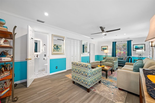 living room with crown molding, light hardwood / wood-style floors, and ceiling fan