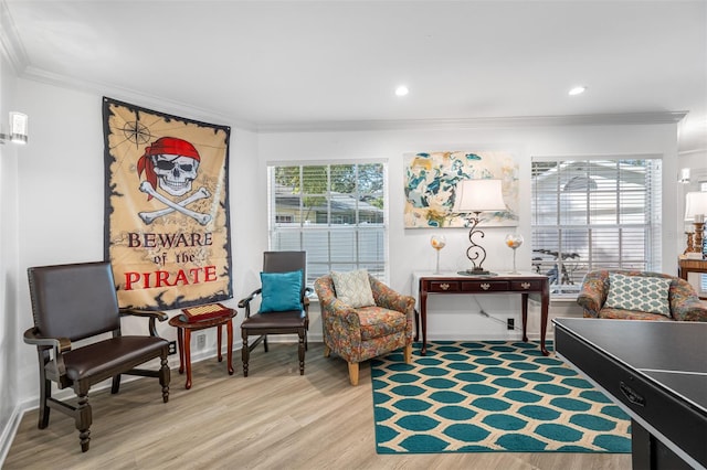 living area with crown molding and hardwood / wood-style flooring