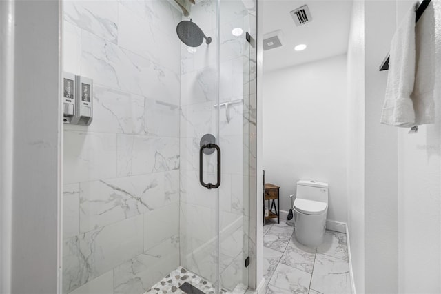 bathroom featuring toilet and a shower with shower door