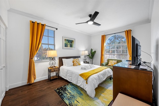 bedroom with ceiling fan, multiple windows, dark hardwood / wood-style flooring, and ornamental molding