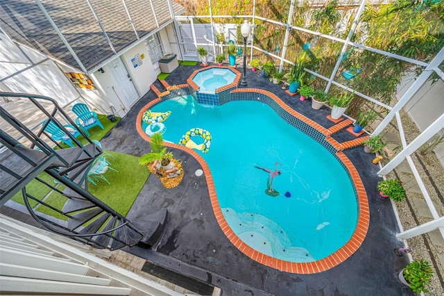 view of pool with an in ground hot tub, glass enclosure, and a patio area