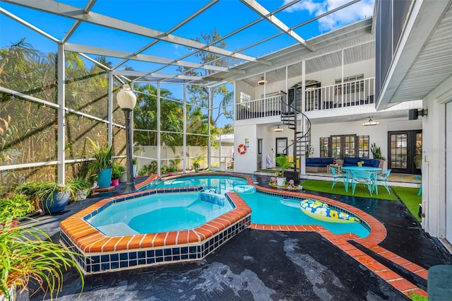 view of pool featuring an in ground hot tub, a lanai, outdoor lounge area, and a patio area