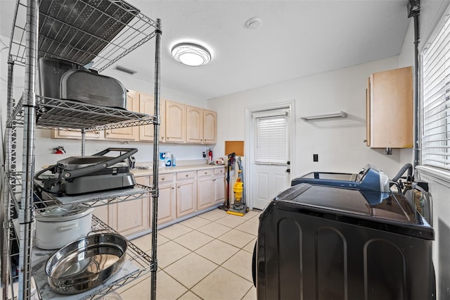 laundry room with light tile patterned floors, plenty of natural light, and washer and dryer