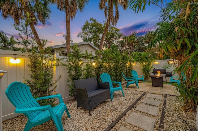 patio terrace at dusk featuring a fire pit