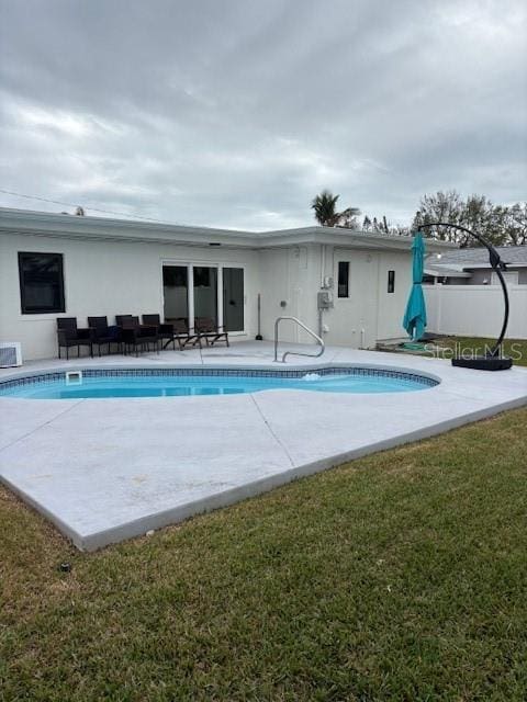 view of pool featuring a patio and a yard