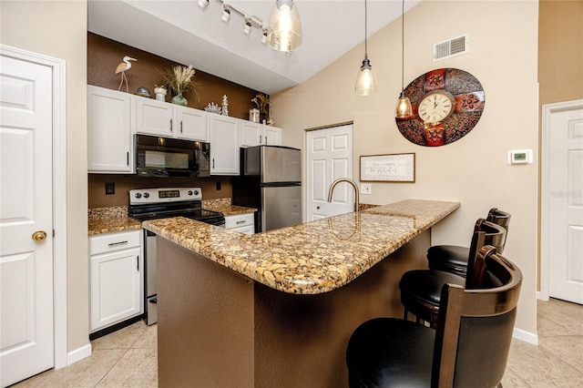 kitchen featuring a kitchen bar, decorative light fixtures, white cabinets, and appliances with stainless steel finishes