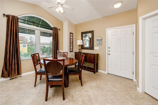 tiled dining area featuring ceiling fan and lofted ceiling