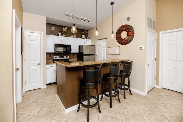 kitchen with stainless steel appliances, decorative light fixtures, a breakfast bar, and white cabinets