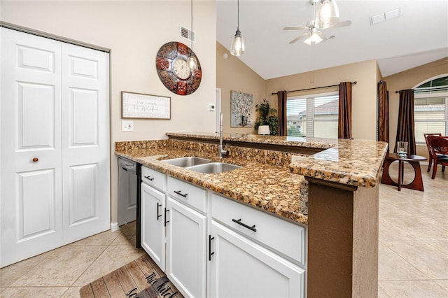 kitchen with lofted ceiling, sink, light tile patterned floors, black dishwasher, and white cabinets