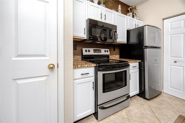 kitchen with white cabinetry, appliances with stainless steel finishes, light tile patterned floors, and stone counters