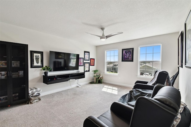 living room with ceiling fan, light carpet, and a textured ceiling