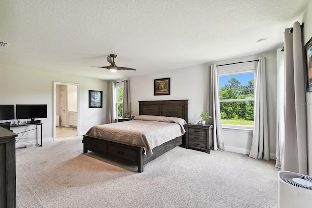 carpeted bedroom featuring multiple windows, ceiling fan, connected bathroom, and a textured ceiling