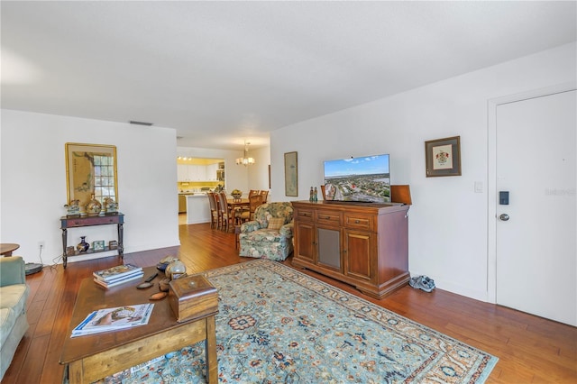 living room with hardwood / wood-style floors and a chandelier