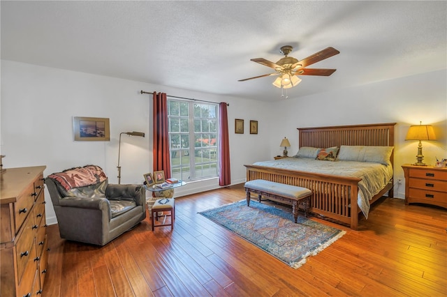 bedroom featuring hardwood / wood-style flooring, ceiling fan, and a textured ceiling