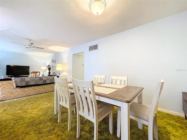 dining space with ceiling fan and carpet flooring