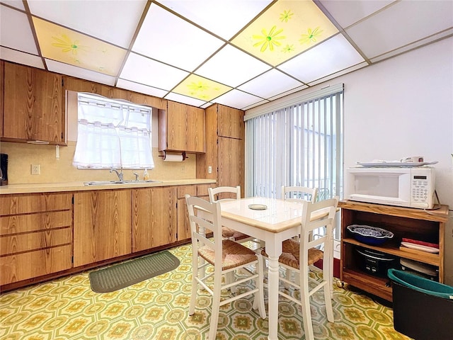 kitchen featuring tasteful backsplash, sink, and a drop ceiling