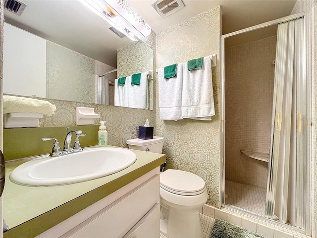 bathroom with vanity, tile patterned flooring, toilet, and walk in shower