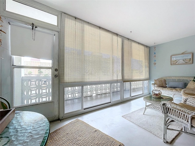 living room featuring concrete flooring and plenty of natural light