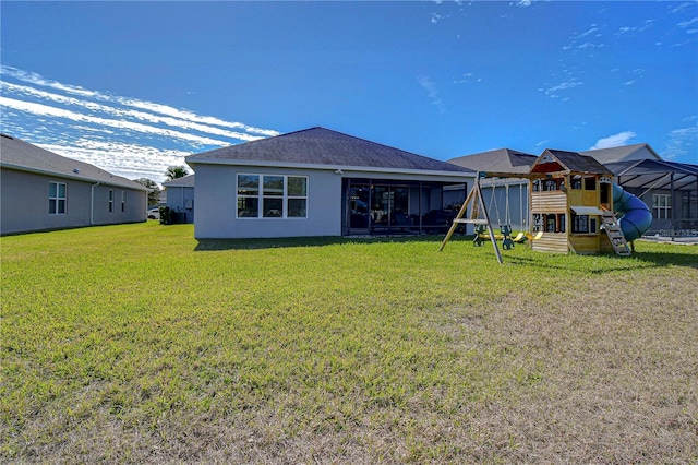 back of house with a playground and a lawn