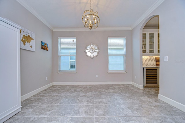 unfurnished dining area with crown molding, a chandelier, beverage cooler, and a healthy amount of sunlight