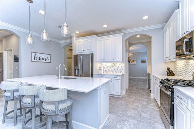 kitchen with a kitchen island with sink, sink, white cabinetry, and stainless steel appliances