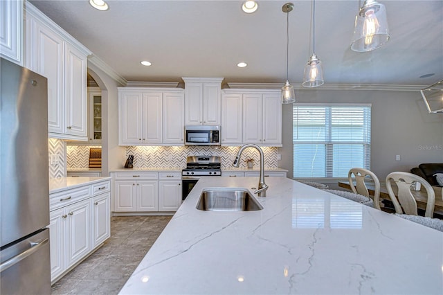 kitchen featuring stainless steel appliances, hanging light fixtures, white cabinets, and light stone counters