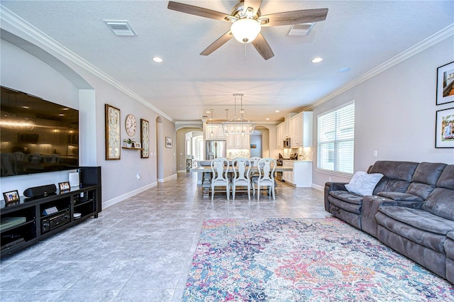 living room with crown molding, ceiling fan with notable chandelier, and a textured ceiling