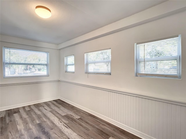 unfurnished room with plenty of natural light and hardwood / wood-style floors