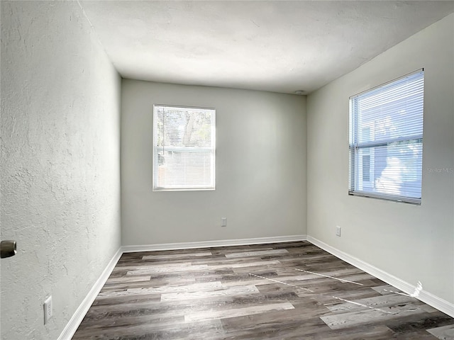 unfurnished room with dark wood-type flooring