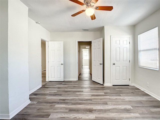 unfurnished bedroom with ceiling fan and light hardwood / wood-style floors