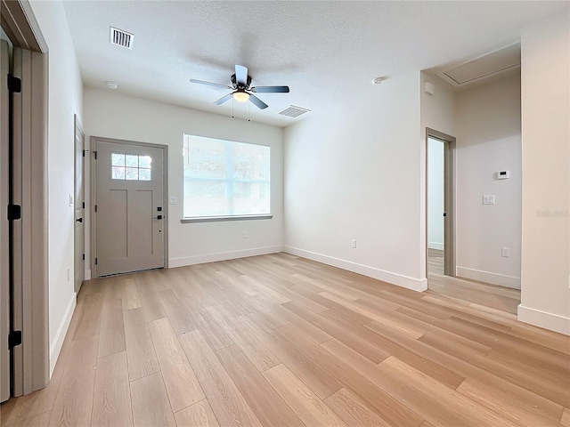 foyer entrance featuring a textured ceiling, light hardwood / wood-style flooring, and ceiling fan