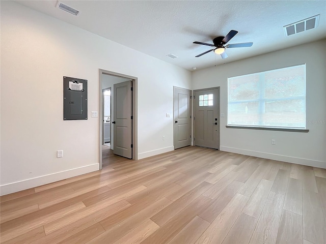 foyer entrance featuring ceiling fan, light hardwood / wood-style floors, a textured ceiling, and electric panel