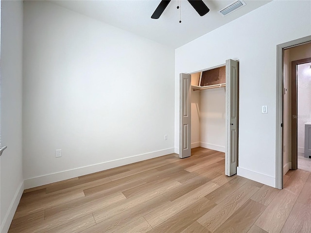 unfurnished bedroom with light wood-type flooring, ceiling fan, and a closet