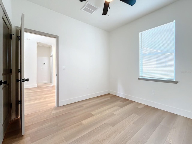 empty room with ceiling fan and light hardwood / wood-style floors