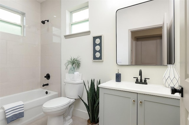 full bathroom featuring vanity, tiled shower / bath combo, a wealth of natural light, and toilet