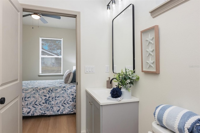 bathroom with hardwood / wood-style flooring, vanity, ceiling fan, and toilet