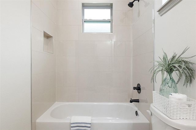 bathroom featuring tiled shower / bath and toilet