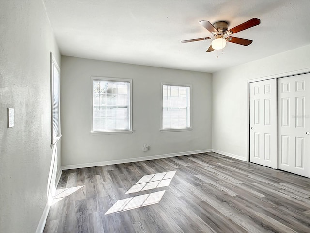 unfurnished bedroom with multiple windows, light hardwood / wood-style floors, and a closet