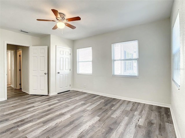 unfurnished bedroom featuring ceiling fan, a closet, and light hardwood / wood-style flooring