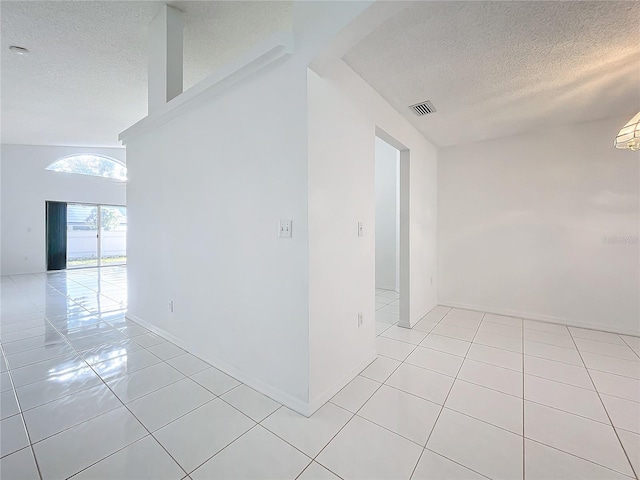 empty room featuring light tile patterned flooring and a textured ceiling