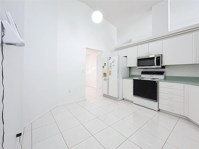 kitchen featuring a towering ceiling, pendant lighting, white cabinetry, white refrigerator with ice dispenser, and electric range