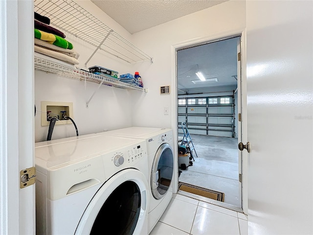 laundry area featuring washing machine and clothes dryer and a textured ceiling