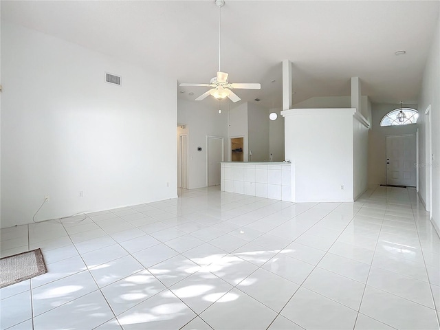 unfurnished living room featuring high vaulted ceiling, ceiling fan, and light tile patterned flooring