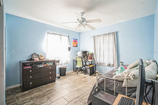 bedroom with ceiling fan and a textured ceiling