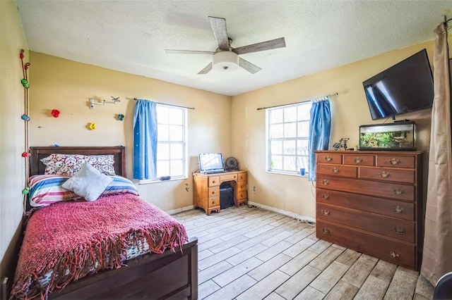 bedroom with ceiling fan and a textured ceiling