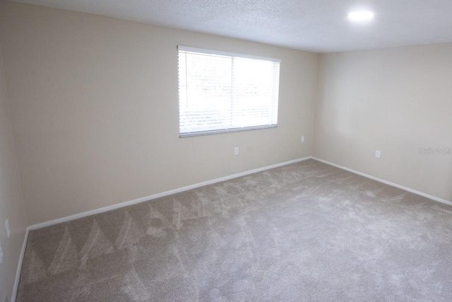 unfurnished room featuring carpet floors and a textured ceiling